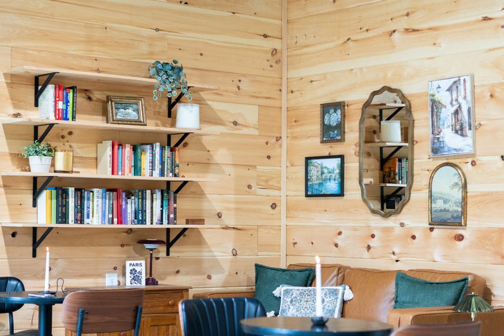 The seating area at Cafe Pilates, pine walls, bookshelves and a teal sofa