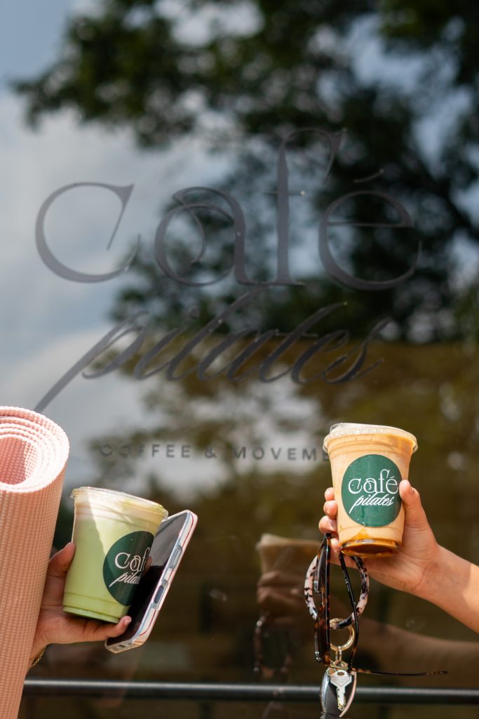 Two Cafe Pilates drinks held up against the etched window