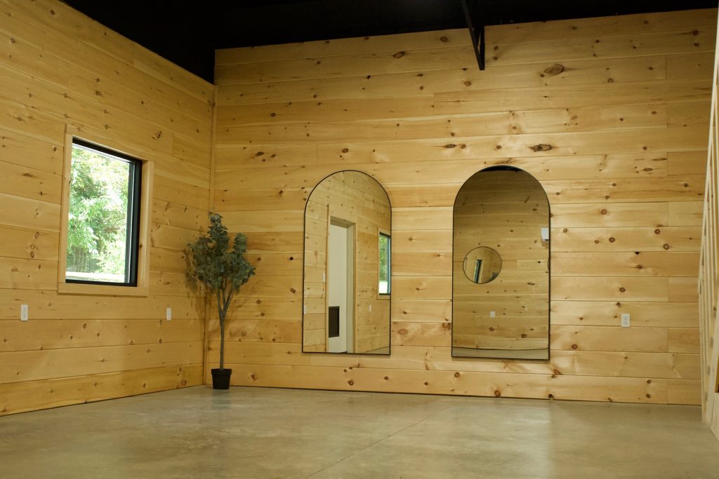 The empty studio at Cafe Pilates, pine walls and a concrete floor